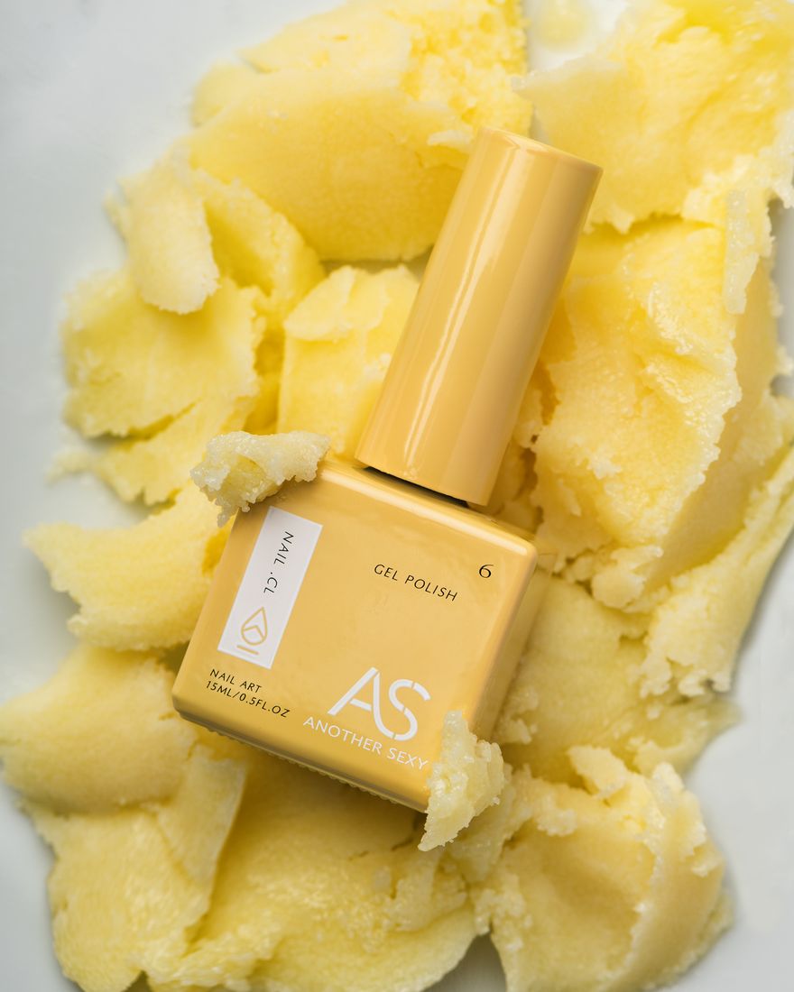 Gel nail polish bottle on a yellow textured background, beauty product photography