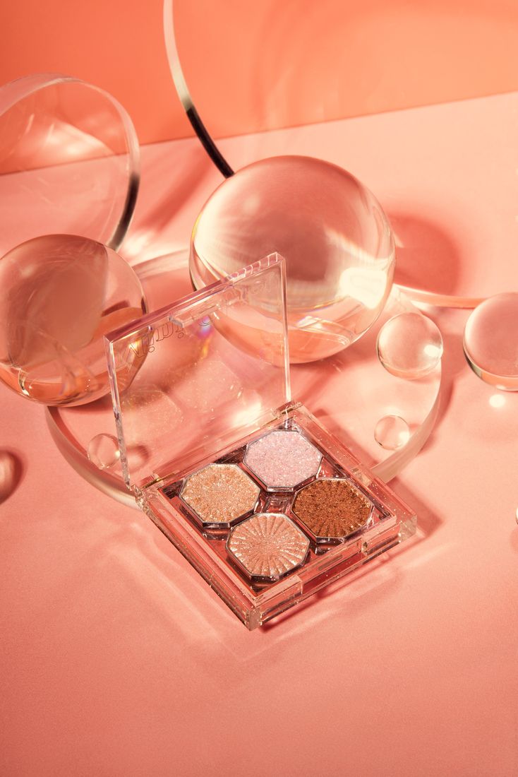Eyeshadow palette flat lay with glass spheres, makeup product photography