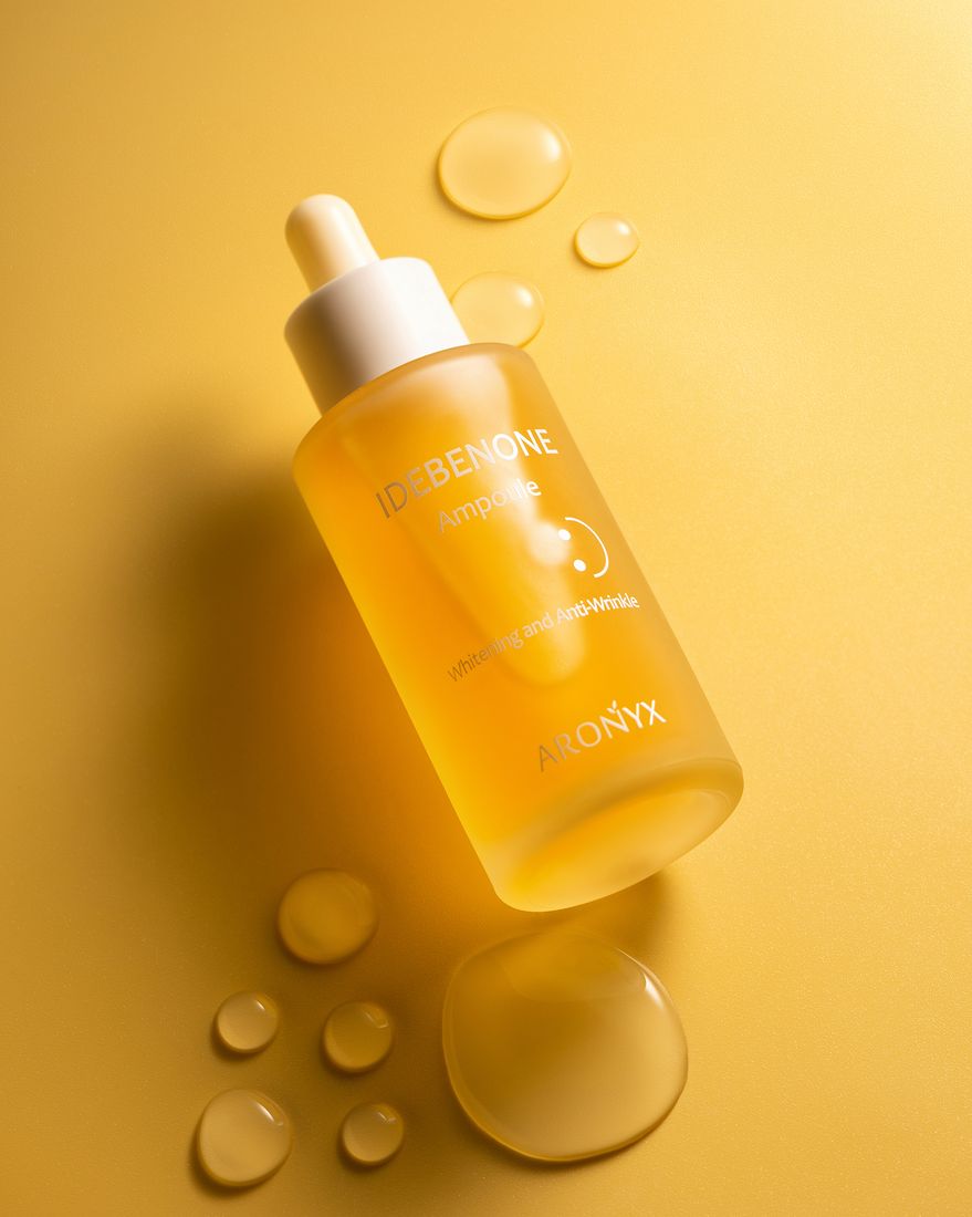Skincare ampoule dropper bottle with serum drops, beauty product photography
